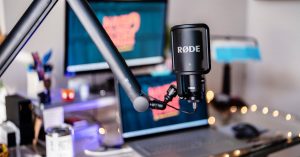 Close-up of a modern podcast studio featuring a RØDE microphone and digital workspace, ideal for content creators.