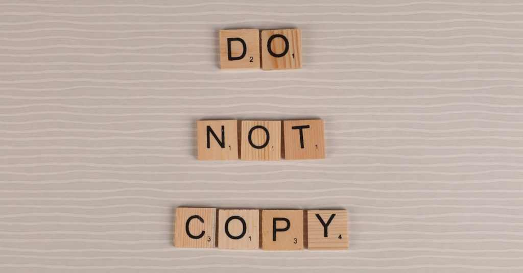 Close-up of wooden tiles spelling 'Do Not Copy' on a textured surface.